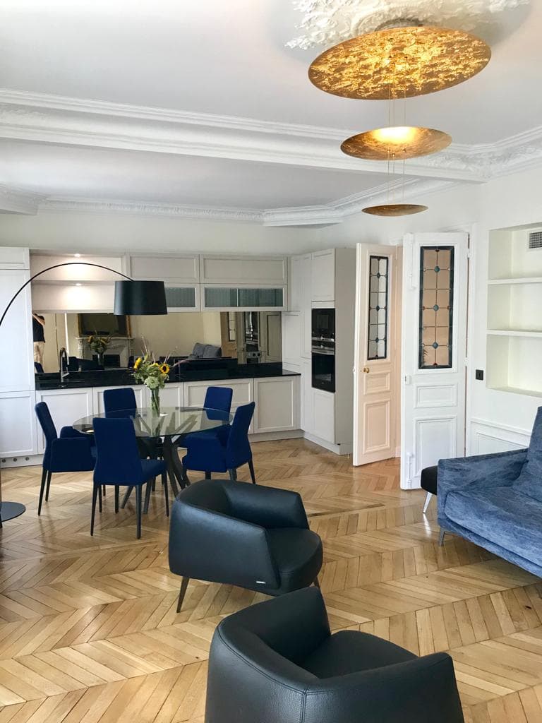 Salon haut de gamme rénové avec parquet point de Hongrie, moulures et suspensions dorées — Paris 4e