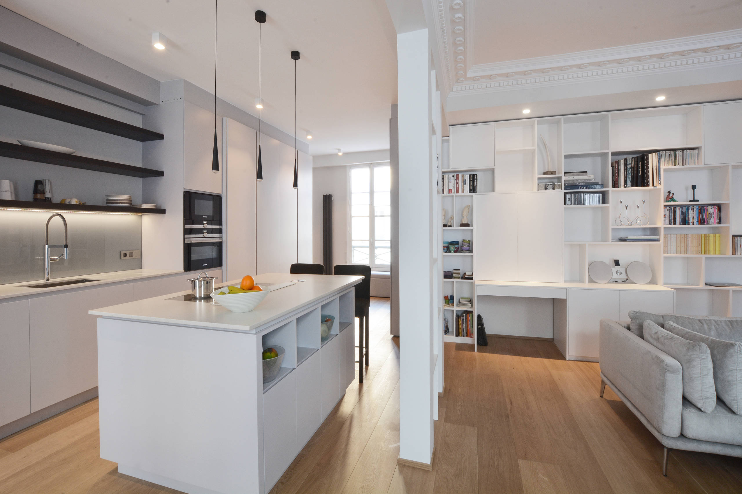 Salon ouvert sur cuisine avec moulures haussmanniennes restaurées, parquet chêne clair et salle à manger — Paris 6e