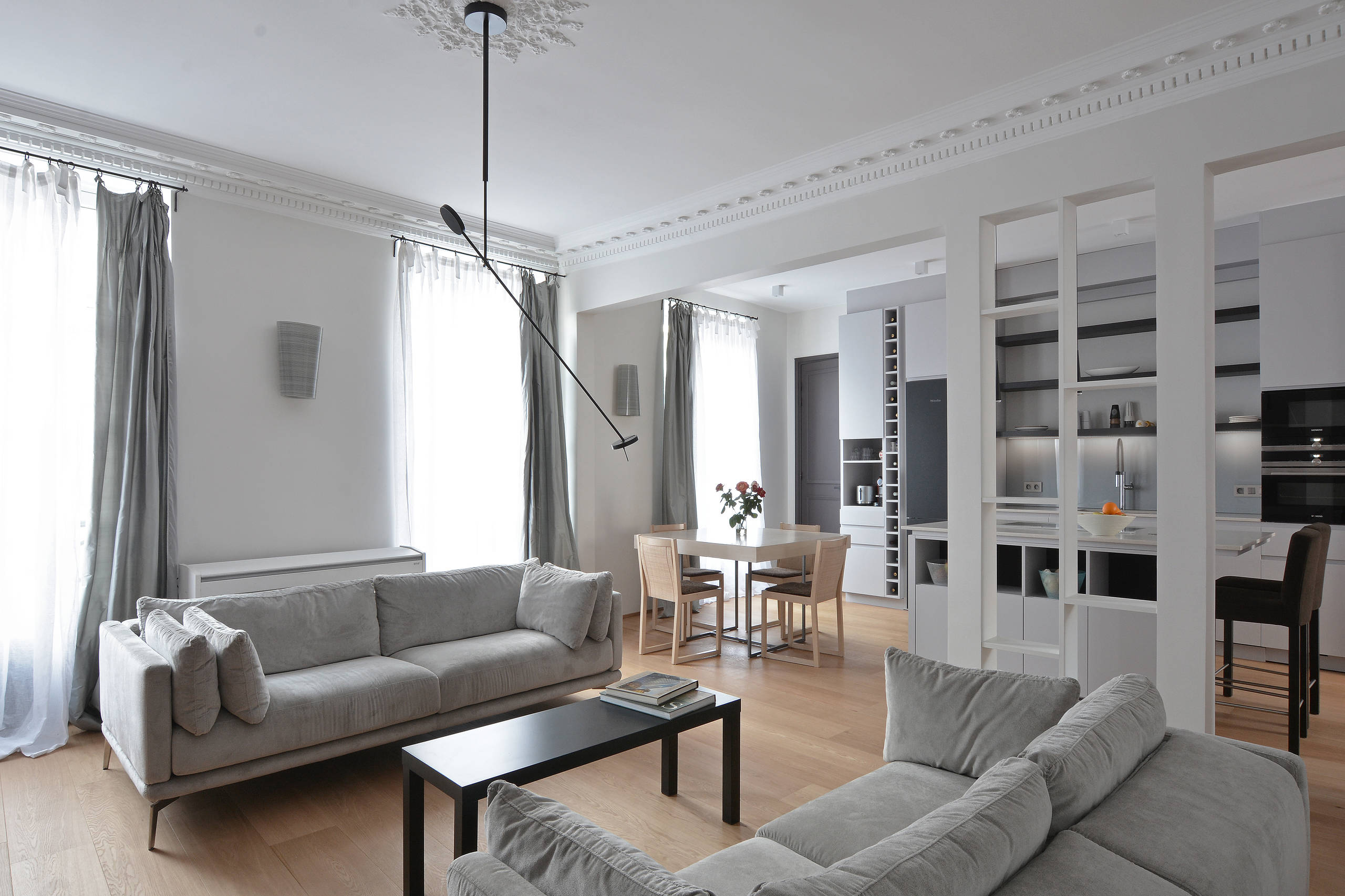 Vue d'ensemble salon-cuisine après ouverture totale d'un mur porteur avec piliers de soutien — rénovation Paris 6e