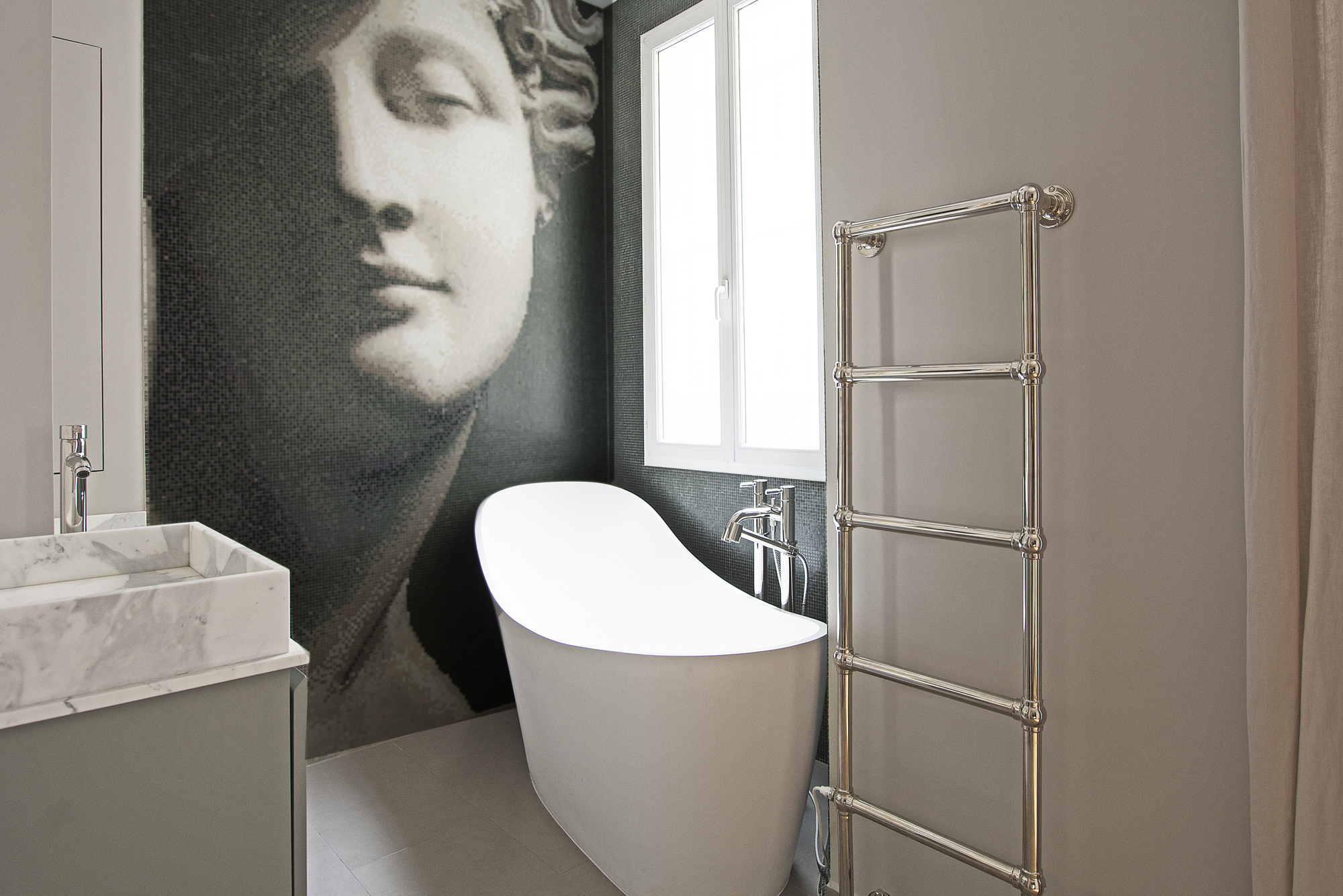 Salle de bain contemporaine avec mosaïque murale sculpture antique, baignoire îlot et sèche-serviettes chromé — Paris 7