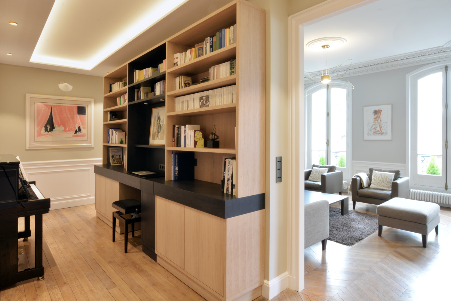 Galerie avec bibliothèque en chêne, piano et éclairage indirect — rénovation Paris 4e